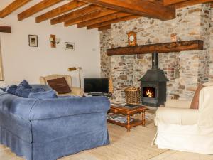 LuppittSwallows Cottage的客厅设有蓝色的沙发和壁炉