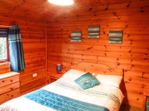 GlenCabin 2的小木屋内一间卧室,配有一张床