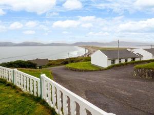 罗斯贝Rossbeigh Beach Cottage No 6的海边道路边的白色房子