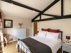 Zeal MonachorumZeal Cottage的一间卧室配有一张带红色枕头的大床