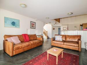科克茅斯Beckside的客厅配有2张棕色皮沙发和1张桌子