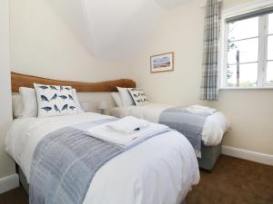 布罗肯赫斯特New Park Farm Cottage的一间卧室设有两张床和窗户。