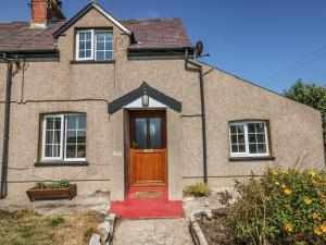 彭布罗克No 2 New Cottages的砖房,有棕色的门和红色地毯