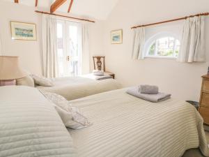 萨德伯里Stable Cottage的一间卧室设有两张床和窗户。