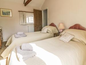 萨德伯里Stable Cottage的一间卧室配有两张带毛巾的床
