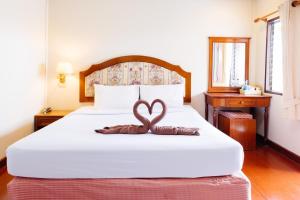 华欣Thipurai Annex Hotel的一间卧室配有一张床,拥有心灵装饰