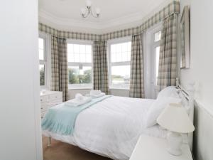 滨海弗林顿Flat 1, Cambridge Court的卧室设有白色大床和窗户。