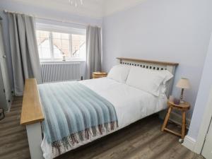 威勒尔Sunlight Soap Cottage的卧室设有一张白色大床和一扇窗户。