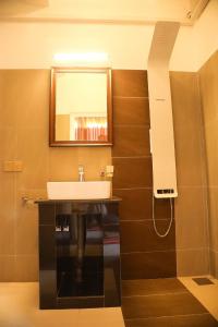 康提Crown & Crown Kandy的浴室设有水槽和墙上的镜子
