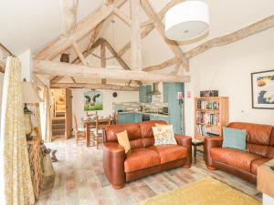 AlvestonMegs Cottage的客厅设有木制天花板和皮革家具。