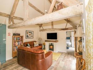 AlvestonMegs Cottage的客厅设有真皮沙发和壁炉