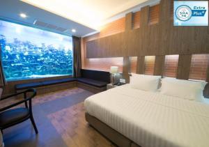 曼谷V20 Boutique Jacuzzi Hotel - SHA Extra Plus的一间卧室设有一张床和一个大窗户