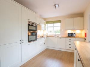 赫里福德Bower View的白色的厨房配有白色橱柜和木地板