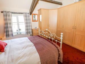 卡斯尔顿Little Bargate的一间卧室设有一张床、一个窗口和木制橱柜。