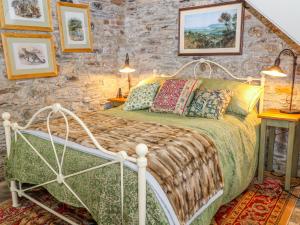 卡林顿The Bothy的一间卧室设有一张床和石墙