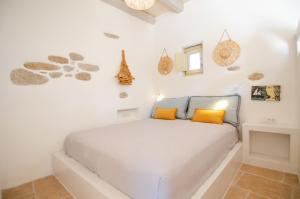 PsathiAnthoula's House的白色卧室配有白色床和橙色枕头