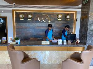 德里久尔MothiMahal Residency Thrissur的两名妇女在餐厅柜台站立