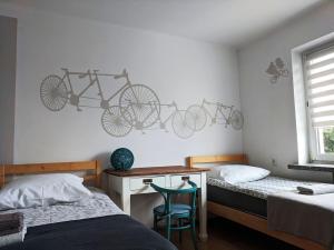 扎莫希奇APARTAMENT 16的卧室配有两张床,墙上配有一张桌子和两辆自行车