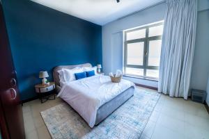 阿卜杜勒国王经济城Mabaat - Beach Tower - Building B - 251的蓝色的卧室设有床和窗户