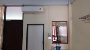 玛哈沙拉堪Sataya Apartment的墙上有门和空调的房间