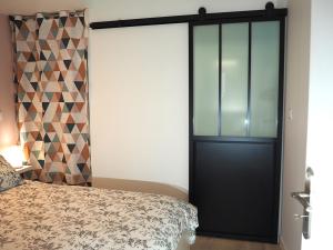 热夫雷尚贝尔坦Le Richebourg - Charmant T2 Cosy, tout confort的卧室设有黑色的门和一张床