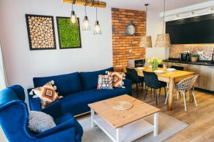 斯克拉斯卡波伦巴Apartament Przytulny Stone Hill的客厅配有蓝色的沙发和桌子