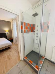 图尔意大利人酒店的一间带淋浴的浴室,位于一间设有床铺的客房