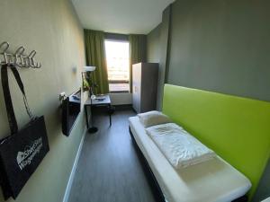 瓦赫宁根Short Stay Wageningen的小房间设有一张床和一张书桌