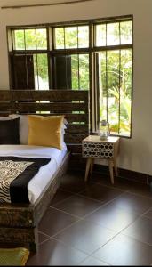 WakisoMabamba Lodge的卧室配有床、桌子和窗户。