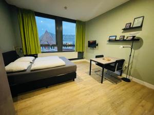 瓦赫宁根Short Stay Wageningen的一间卧室配有一张床、一张书桌和一个窗户。