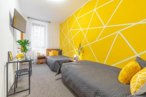 布尔诺Penzion Expo Dream #33 by Goodnite cz的一间卧室设有两张床和黄色的墙壁