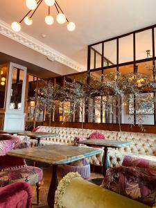 邓莱里哈丁顿酒店的餐厅设有2张桌子和椅子以及窗户。