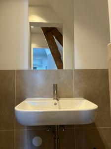 诺德韦克Weltevreden的浴室设有白色水槽和镜子