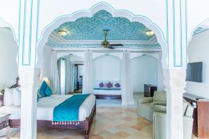 斋浦尔哈瓦里文化遗址酒店的一间卧室配有一张特大号床和一张沙发