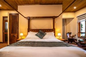 坎帕拉Divine Resort & Spa的一间卧室配有一张大床和两盏灯。