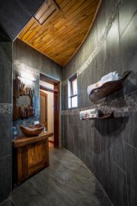 坎帕拉Divine Resort & Spa的一间带两个盥洗盆和木制天花板的浴室