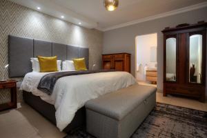 阿多Longhill Lodge的大卧室配有一张带黄色枕头的大床