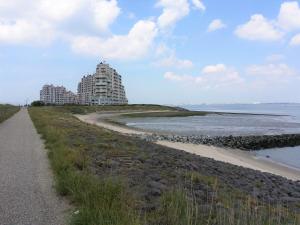 布雷斯肯斯Kustverhuur, Prachtig appartement met uitzicht op zee, Port Scaldis 09-051的海滩旁的一条小路,有一座建筑
