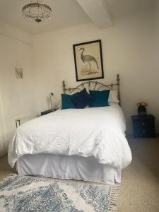 布由德利Mingo Cottage的卧室配有带蓝色枕头的大型白色床