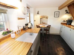 大莫尔文Ivy Cottage的厨房配有水槽和木制台面