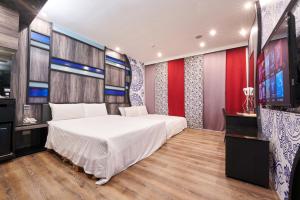 台南凯渥汽车旅馆的卧室配有一张白色大床和一台平面电视。