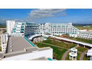 IskeleLimak Cyprus Deluxe Hotel的一座白色的大建筑,前面设有一个游泳池