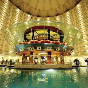 苏拉特Rajhans Belliza Luxurious Studio Apartment的一座大型建筑,前面设有一个游泳池