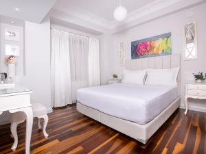 比于卡达Ascot Hotel Büyükada的白色卧室配有白色的床和白色的书桌