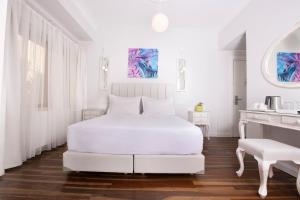 比于卡达Ascot Hotel Büyükada的白色的卧室配有白色的床和一张桌子