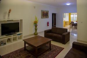 阿克拉RESIDENCE IVOIRE的客厅配有电视、沙发和桌子