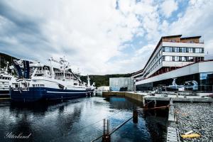 Fosnavåg佛斯纳沃格雷神酒店的两艘船停靠在大楼旁边的码头