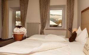 圣洛伦佐-迪塞巴托马丁内霍夫酒店的一间卧室设有两张白色的床和窗户