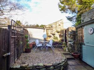 WolsinghamMill Cottage的一个带桌椅和围栏的庭院