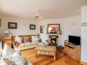海上费萨德Driftwood Cottage的带沙发和壁炉的客厅